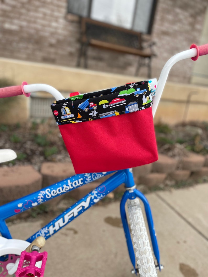 May include: A blue children's bicycle with white handlebars, a red and black handlebar bag, and the words "Seastar" and "HUFFY" on the frame.