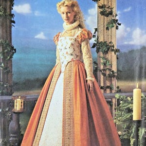 May include: Simplicity 8881 Elizabethan Costume Collection sewing pattern envelope. The front features a gown with a white floral bodice, orange skirt panels, long sleeves, and a high ruffled collar. Sizes HH 6, 8, 10, 12 are listed on the package.