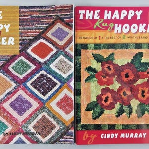 May include: Two instructional books by Cindy Murray titled The Happy Rug Hooker and The Happy Rug Hooker 3. The first cover displays a colorful diamond-patterned rug, while the second cover features a floral rug design on a green checkered background.