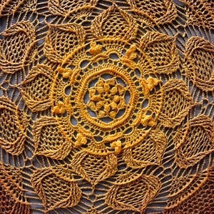 Könnte beinhalten: Eine gehäkelte Tischdecke mit einem runden Design in Orange- und Gelbtönen.