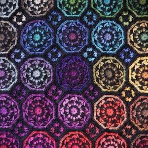 Può includere: Una coperta all'uncinetto colorata con un motivo ripetitivo di ottagoni. Gli ottagoni sono realizzati con filati di diversi colori, creando un effetto arcobaleno.