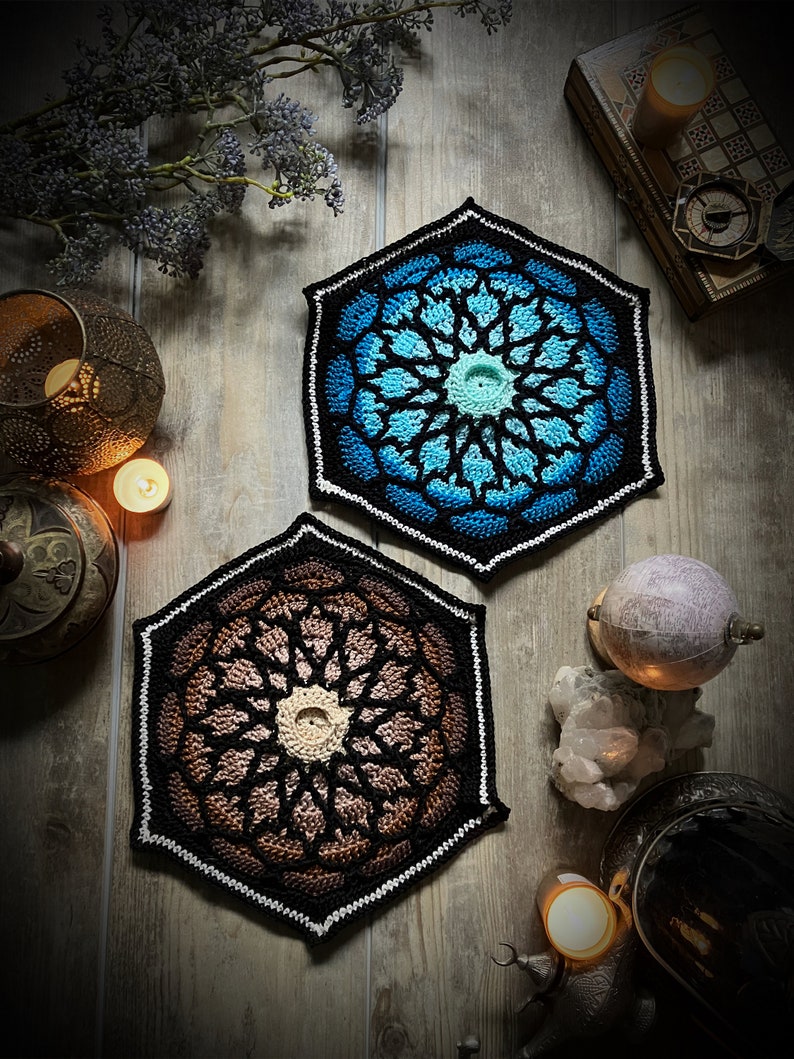May include: Two crocheted hexagonal coasters with intricate geometric patterns. One coaster is blue and white, the other is brown and white.