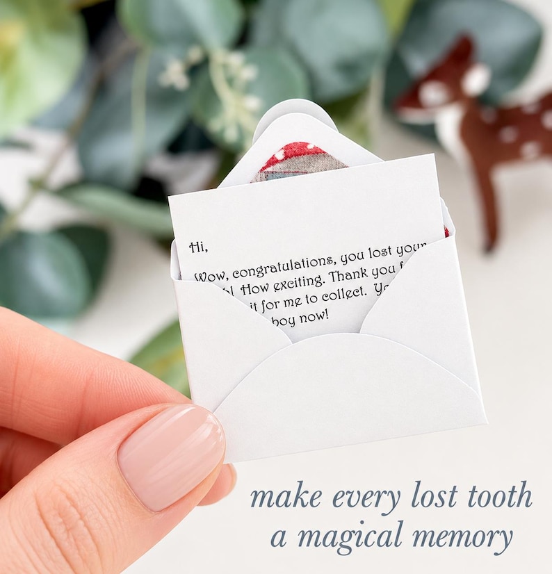 K&ouml;nnte beinhalten: Ein Miniatur-Briefumschlag aus wei&szlig;em Papier mit einer kleinen Notiz, auf der gedruckter Text steht: Hi, Wow, congratulations, you lost your tooth! How exciting. Thank you for leaving it for me to collect. You are a big boy now! Der Umschlag ist offen.