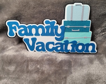 May include: A layered paper cutout featuring the words "Family Vacation" in blue and white. Stacked on the right are three suitcases in shades of blue and teal. The cutout is on a gray, textured background.