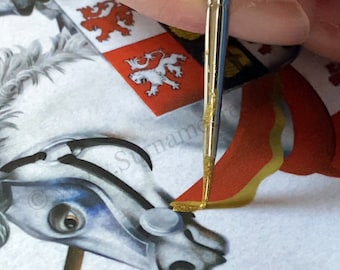 Könnte beinhalten: Nahaufnahme einer Hand, die einen kleinen Pinsel verwendet, um goldene Farbe auf ein rot-weißes heraldisches Schild mit einem Löwenmotiv aufzutragen. Das Schild ist Teil eines größeren Wappens.