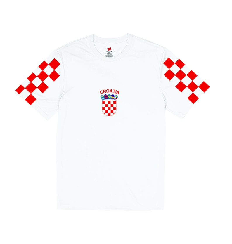 May include: White t-shirt with red and white checkered sleeves and a red and white checkered Croatian coat of arms on the front. The text 'CROATIA' is above the coat of arms.