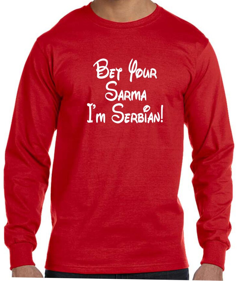 May include: Red long-sleeve t-shirt with white text that reads "Bet your sarma I'm Serbian!" in a stylized font.