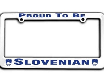 May include: White plastic license plate frame with blue text that reads "Proud to be Slovenian". The frame has two blue Slovenian coat of arms on either side of the text.