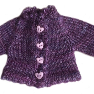 May include: A purple knitted cardigan with a ruffled neckline and heart-shaped buttons.