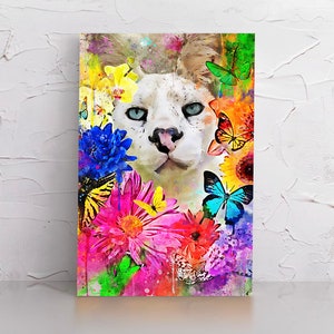 Puede incluir: Un gato blanco con ojos azules rodeado de flores y mariposas de colores. El gato mira directamente al espectador. El fondo es una acuarela de color rosa, azul y verde.