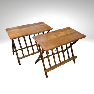 May include: Two brown wooden folding tables with a slatted design. The tables have a rectangular top and a shelf underneath.