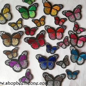 Peut inclure: Assortiment de patchs brodés de papillons colorés à repasser. Les patchs présentent différents motifs de papillons dans des tons de rouge, bleu, vert, violet, orange et marron.  www.shopbeethezome.com