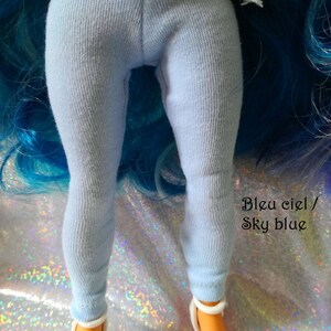 May include: Light blue leggings for a doll. The leggings are made of a soft, stretchy fabric. The text "Bleu ciel / Sky blue" is written on the image.
