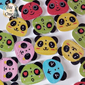 Peut inclure: Assortiment de boutons en bois en forme de panda de différentes couleurs, notamment jaune, vert, rose, bleu et rouge. Chaque bouton représente un visage de panda avec des yeux noirs, un nez noir et une bouche noire. Certains boutons présentent des détails supplémentaires comme des cœurs, des rayures et des points.
