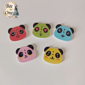 Peut inclure: Cinq boutons en bois en forme de panda avec des expressions différentes. Les boutons sont rouge, vert, bleu, rose et jaune. Chaque bouton a deux yeux noirs et un nez noir.
