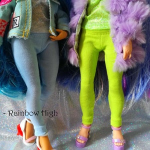 May include: Two dolls wearing colorful outfits and platform shoes. The doll on the left is wearing a blue denim jacket with a heart patch, a silver glitter top, and light blue leggings. The doll on the right is wearing a purple furry jacket, a green glitter top, and bright green leggings. Both dolls are wearing platform shoes with a rainbow design.