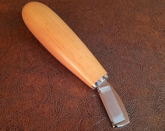 May include: A wooden handled craft knife with a silver blade. The blade is sharp and has a slight curve to it.
