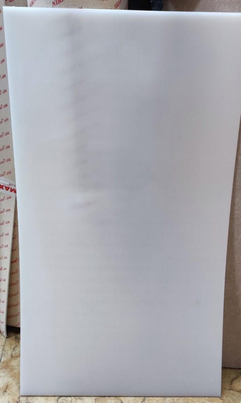 Puede incluir: Una gran l&aacute;mina rectangular de material de espuma blanca. La espuma parece lisa y s&oacute;lida, con una ligera curvatura en el borde derecho. La l&aacute;mina est&aacute; colocada verticalmente, ocupando la mayor parte del encuadre.