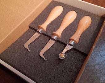 May include: Three leather working tools with wooden handles and metal blades. The tools are in a foam-lined box. The tools are labeled "Cobra" and "10".