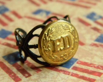 Divertido anillo ajustable de disfraz del Departamento de Bomberos, hecho con un botón de latón de uniforme antiguo y una banda decorativa ajustable con acabado de latón envejecido.