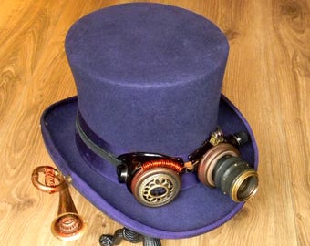 ¡Obra maestra de la sombrerería steampunk! Sombrero de copa de fieltro de lana estilo victoriano en color púrpura real con gafas iluminadas y aparato protésico de sonido.