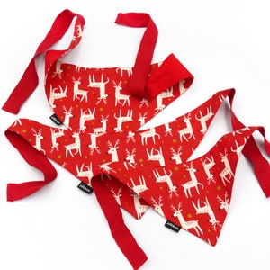 May include: Three red and white patterned bandana style dog bandanas with reindeer designs. The bandanas have red ties.