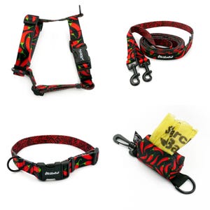 Puede incluir: Un arn&eacute;s, una correa, un collar y un portador de bolsas para perros rojo y negro con un estampado de chile. La marca "Primal Pet" est&aacute; impresa en los productos.