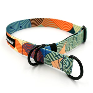 Peut inclure: Un collier de chien coloré avec un motif géométrique dans des tons de bleu, orange et vert. Le collier a une boucle en métal noir et deux anneaux en D. Le texte "PolkaDot" est imprimé sur le collier.
