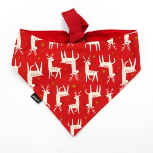 May include: Red bandana with a white reindeer pattern. The bandana has a tie at the top and is made of cotton.