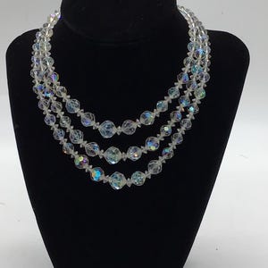 Vintage graduated Czech faceted clear and AB glass triple strand bead necklace.