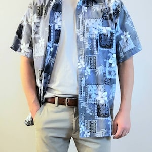 May include: A blue and white patterned short-sleeved shirt with a white t-shirt underneath and khaki pants.