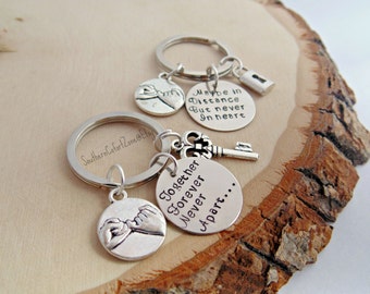 May include: Silver keychain with two charms. One charm has the text "Together Forever Never Apart..." and the other charm has the text "Maybe in Distance But never In heart".