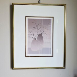 May include: A framed print of a still life featuring two gray vases with a branch of bare twigs in the center. The print is titled "La Branche" and signed "Pierre Huard".
