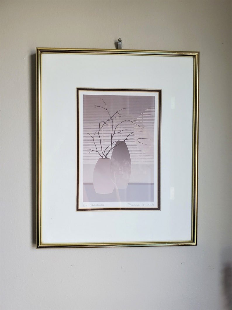 May include: A framed print of a still life featuring two gray vases with a branch of bare twigs in the center. The print is titled "La Branche" and signed "Pierre Huard".