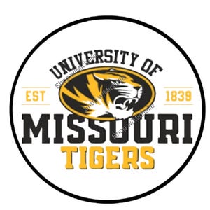 May include: A circular design featuring the words "UNIVERSITY OF MISSOURI" and "TIGERS" in black and gold. The center showcases a roaring tiger head within an oval. The year "1839" and the word "EST" are also included.