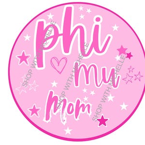 May include: A pink circular graphic with the words "Phi Mu Mom" in a white script font. The design includes white stars and a heart on a light pink background. The words "Shop with Michelle" are repeated around the circle.
