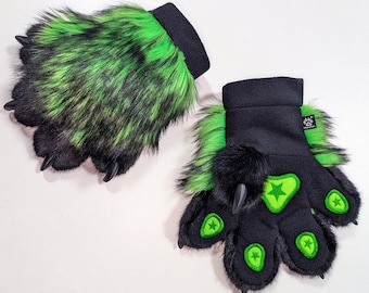 May include: A pair of furry paw gloves. The gloves are black with green accents and feature long, black claws. The paw pads are green with a star design. The wrist cuffs are black.