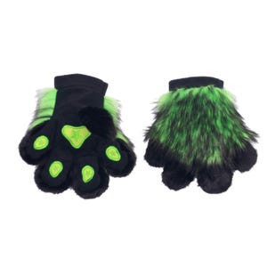 May include: A pair of black and green furry paw gloves. The gloves have black palms with green star-shaped accents and black cuffs. The fur is green and black, creating a striking contrast.