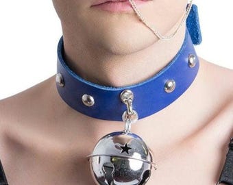 May include: A blue leather choker necklace with silver-toned rivets and a large silver bell pendant. The bell has a star cutout and a jingle sound. The choker is fastened with a silver clasp.