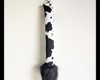 Cola de vaca muu, esponjosa y peluda, de piel sintética.