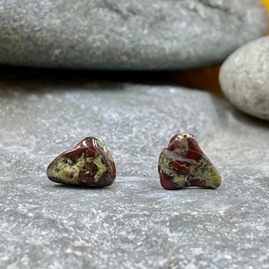 May include: A pair of earrings made from green and red jasper stones. The stones are irregularly shaped and have a natural, organic look.