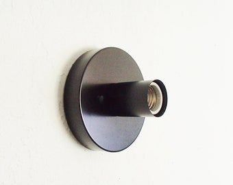 May include: A black metal wall sconce with a single light bulb socket.