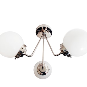 May include: A chrome ceiling light fixture with three white globe-shaped shades.
