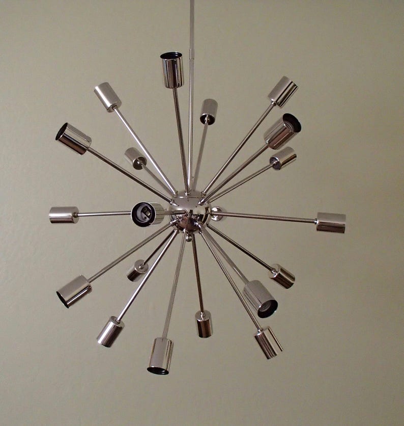 May include: A chrome Sputnik chandelier with multiple arms extending outward from a central sphere. The chandelier has a modern, mid-century design.