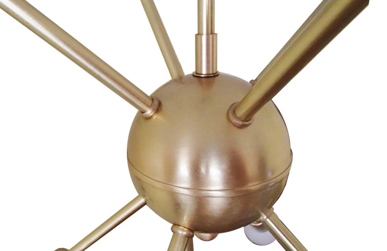 May include: A gold metal chandelier with a spherical center and six arms extending outward. The arms are all the same length and are evenly spaced around the center sphere.