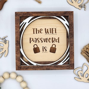 May include: A wooden sign with a brown frame and a white circle in the centre. The sign says "The WiFi password is..." with two lock icons on either side of the word "is".