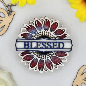 May include: Wooden sunflower with a red and blue paint design and the word "BLESSED" in a white banner.