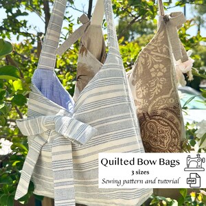 May include: Three quilted bow bags in various fabrics hang from a tree branch. One bag features blue and white stripes, another has a floral pattern, and the third has a neutral linen-like fabric. Text on the image reads "Quilted Bow Bags, 3 sizes, Sewing pattern and tutorial."