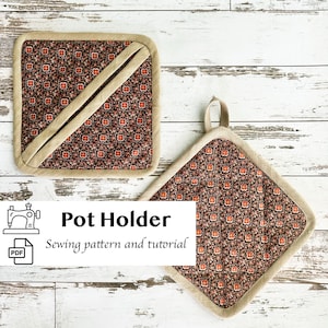 May include: Two square pot holders with a floral pattern in shades of red, orange, and brown on a black background. The pot holders have a beige border and a beige diagonal accent. One pot holder has a loop for hanging. Text on the image reads "Pot Holder Sewing pattern and tutorial."