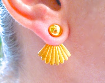 May include: Gold earrings with a round ball at the top and a fan-shaped design hanging down.